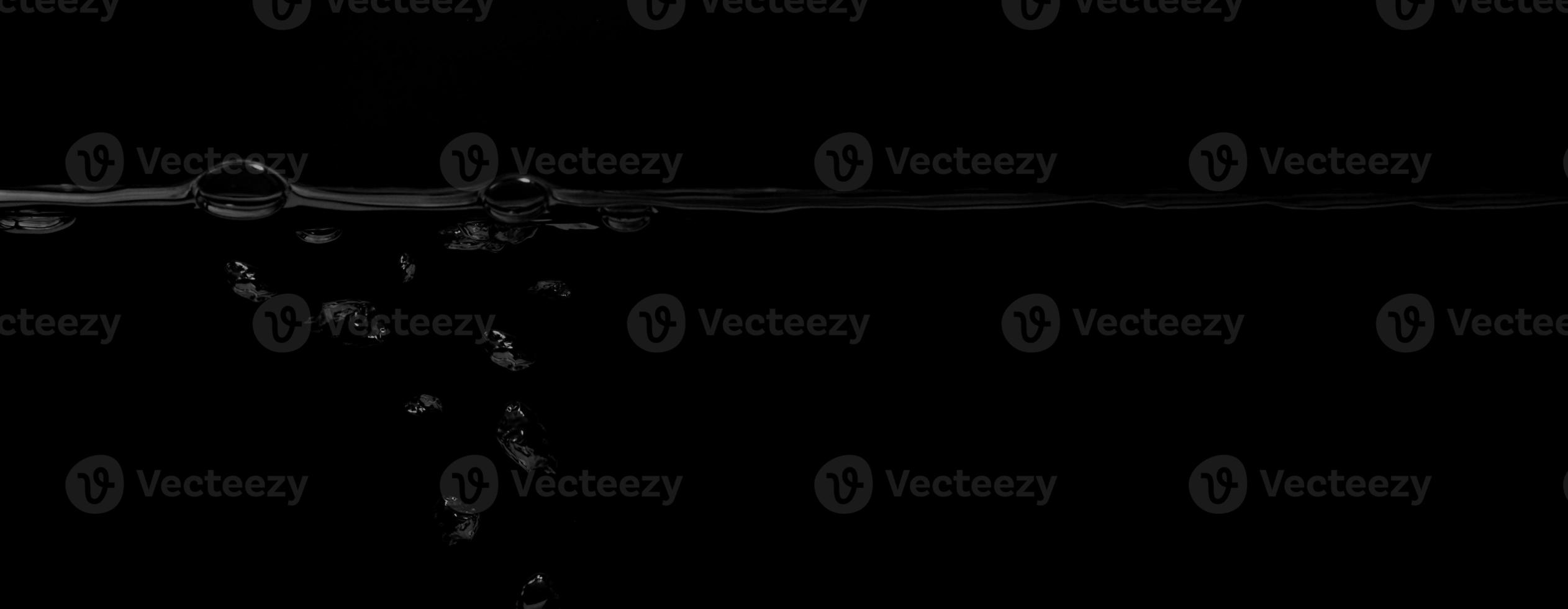 Liquid suface line between underwater and above water with black background. photo