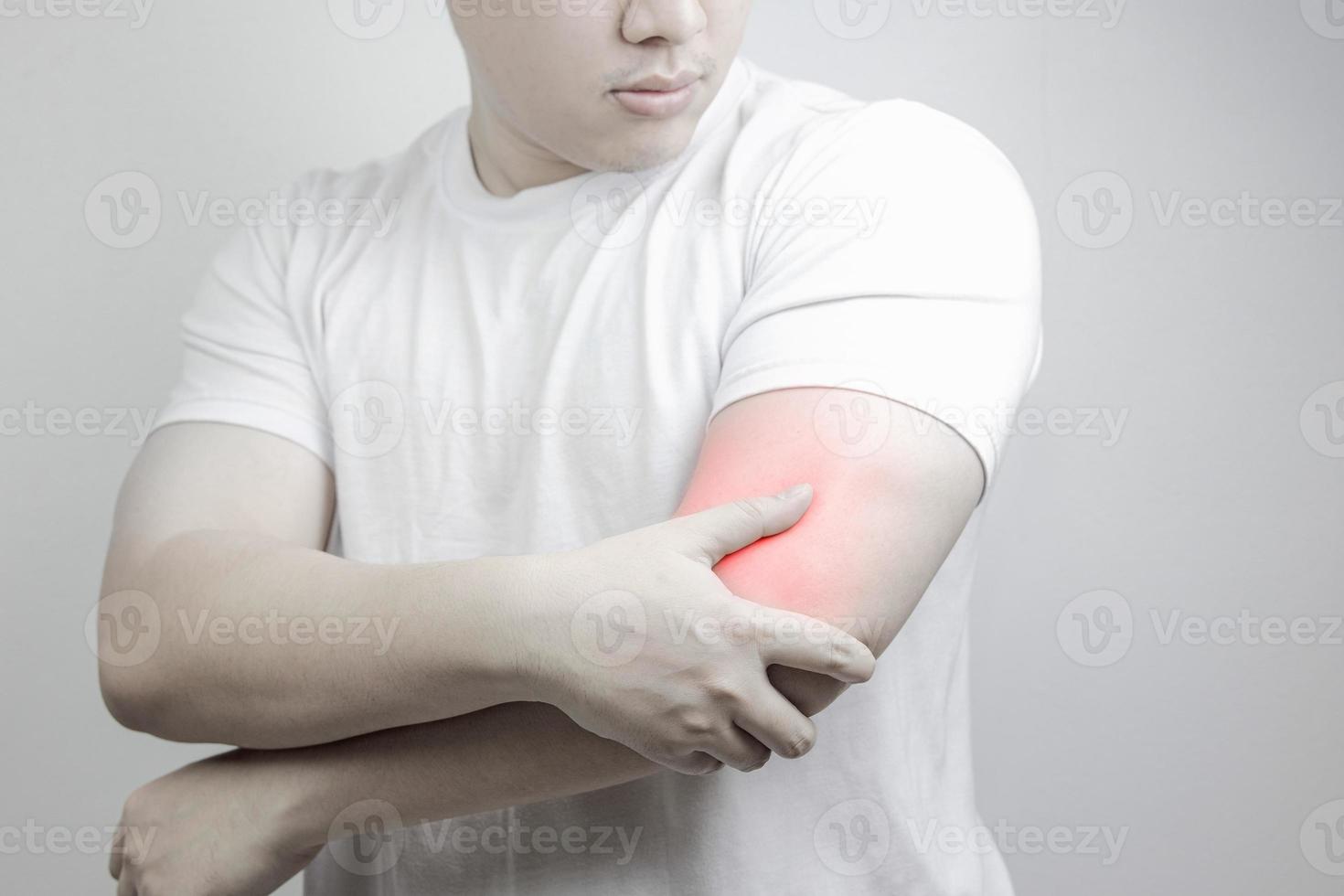 Muscle pain, arm pain, burning sensation, weak muscles, Office syndrome, Muscle tear caused by exercise, red inflamed zone. man having arm pain on a gray background. concept of healthcare photo