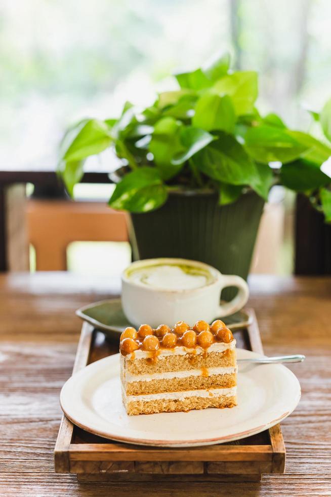 cobertura de pastel de caramelo de macadamia con nueces de macadamia con café en la mesa. foto