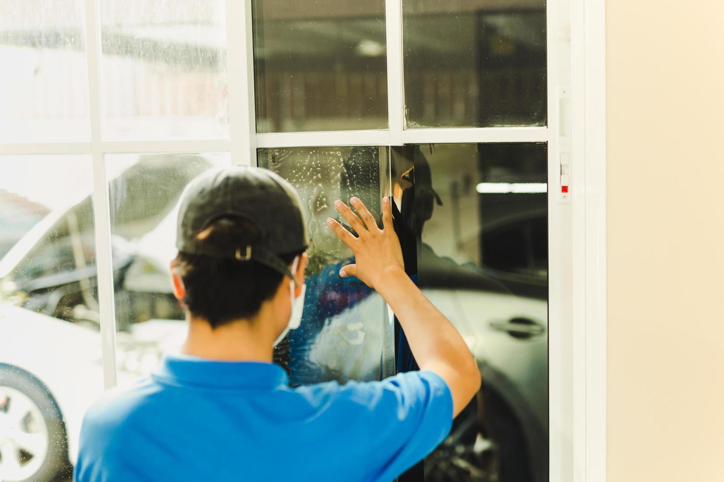 Woker wrapping tinting a house window with tinted foil. photo