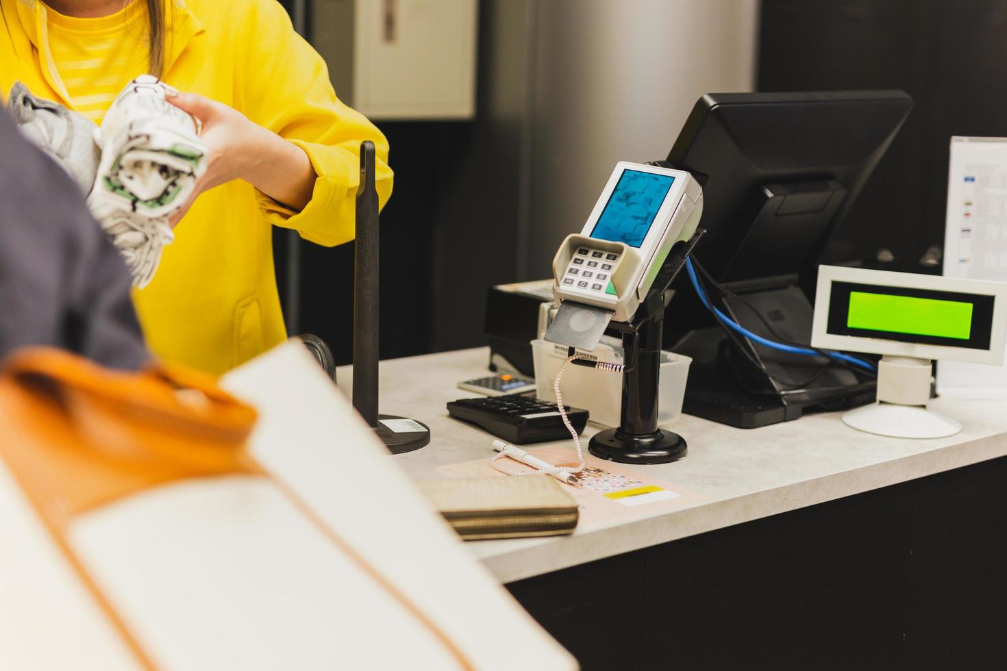 Woman customer paying via credit card using NFC technology in shopping mall. photo