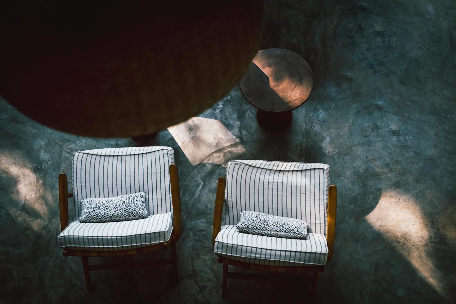 Top view on dark living room interior with coffee table and chair on concrete floor. photo