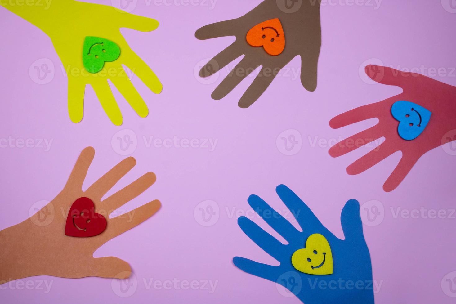 Multicolored paper palms and hearts on a pink background. The concept of friendship of peoples photo