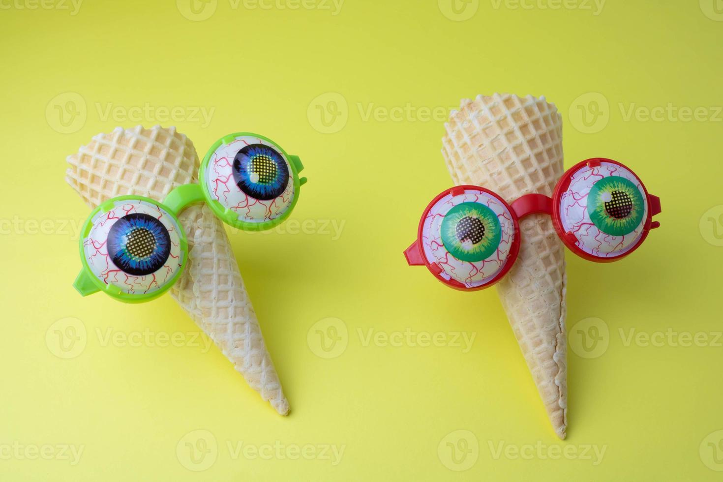 Creative photo of empty waffle cones on a yellow background with glasses. Halloween and Carnival concept