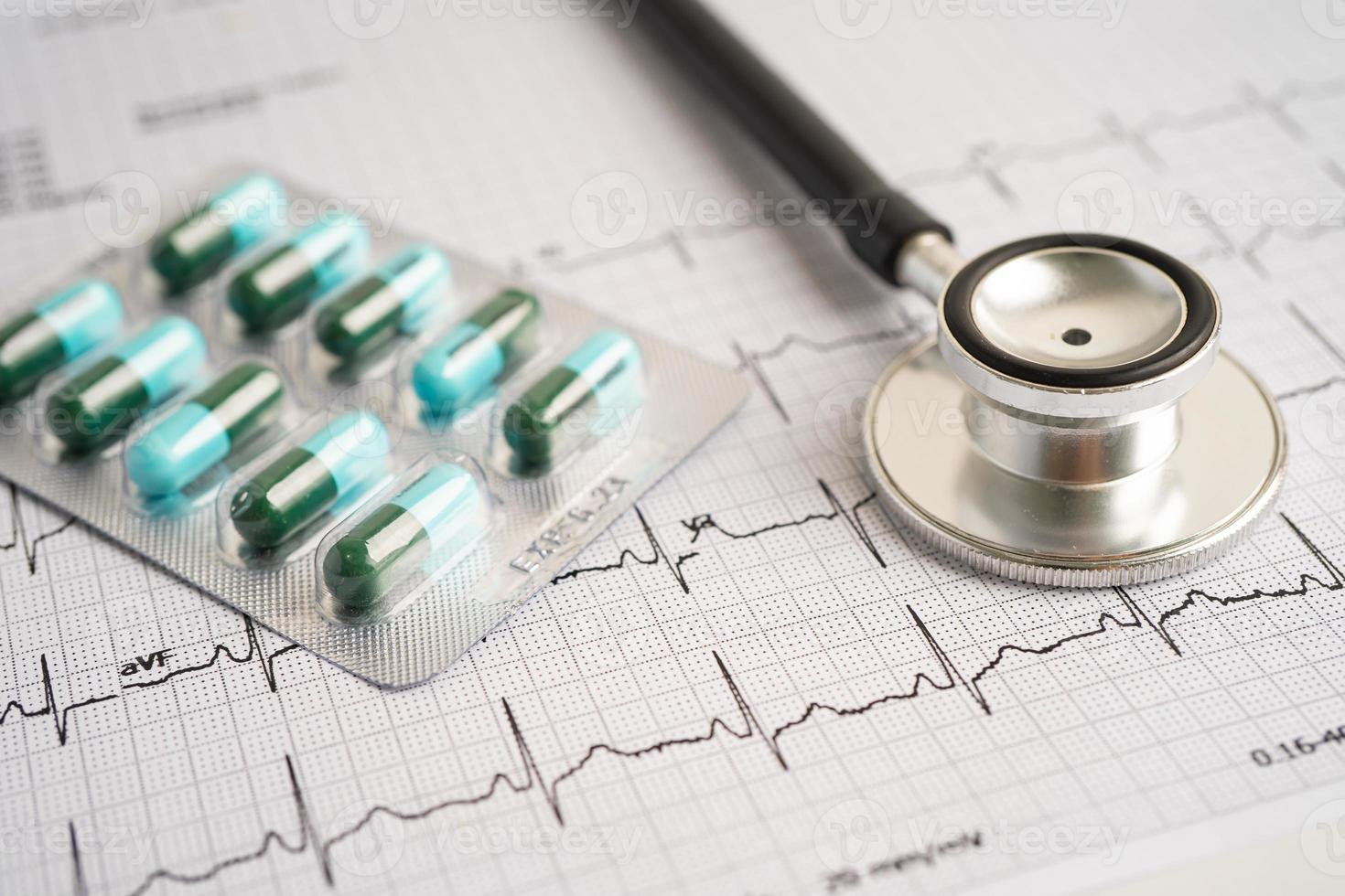 Stethoscope on electrocardiogram with capsule pill, heart wave, heart attack, cardiogram report. photo