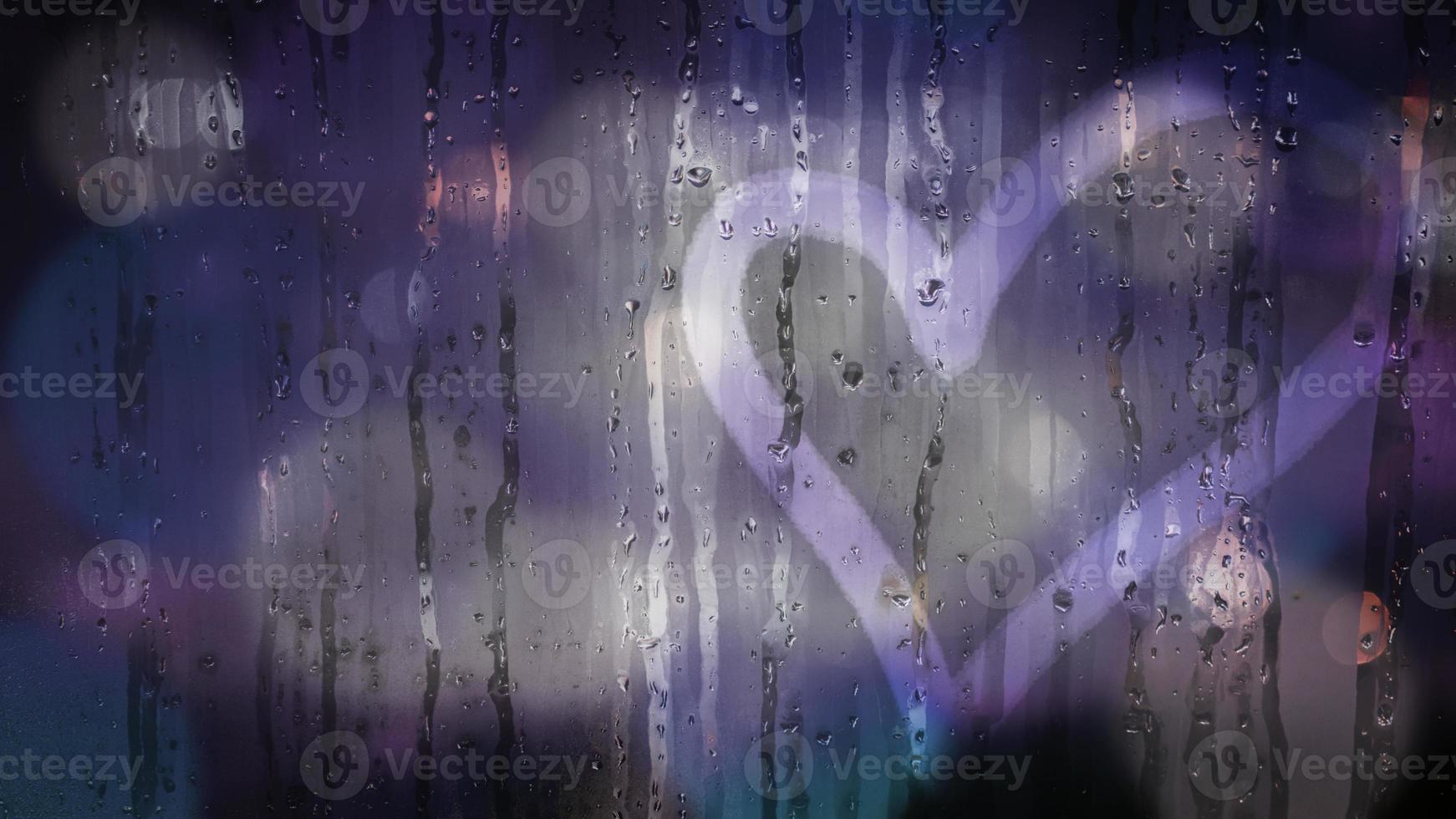 Heart shape on wet grass with water drops and colorful city light bokeh. Hand drawn heart on glass window surface, rainy day. Romance love bubble droplets backdrop. Sadness romantic rain. Concept love photo