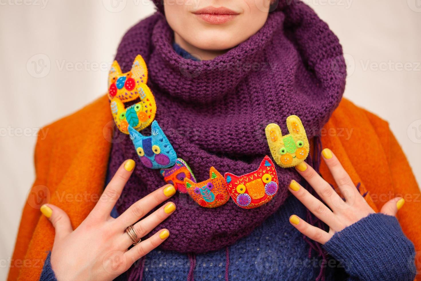 beautiful brooches face of animals close up on the scarf of a girl with a manicure photo