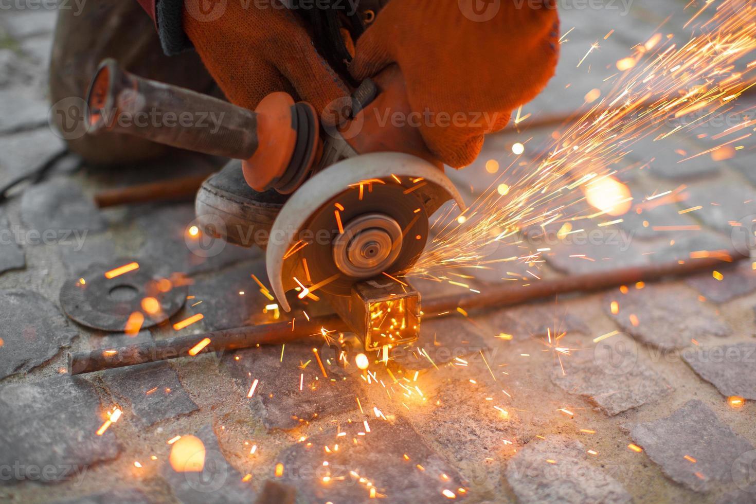 Angular grinding machine cuts metal with sparks photo