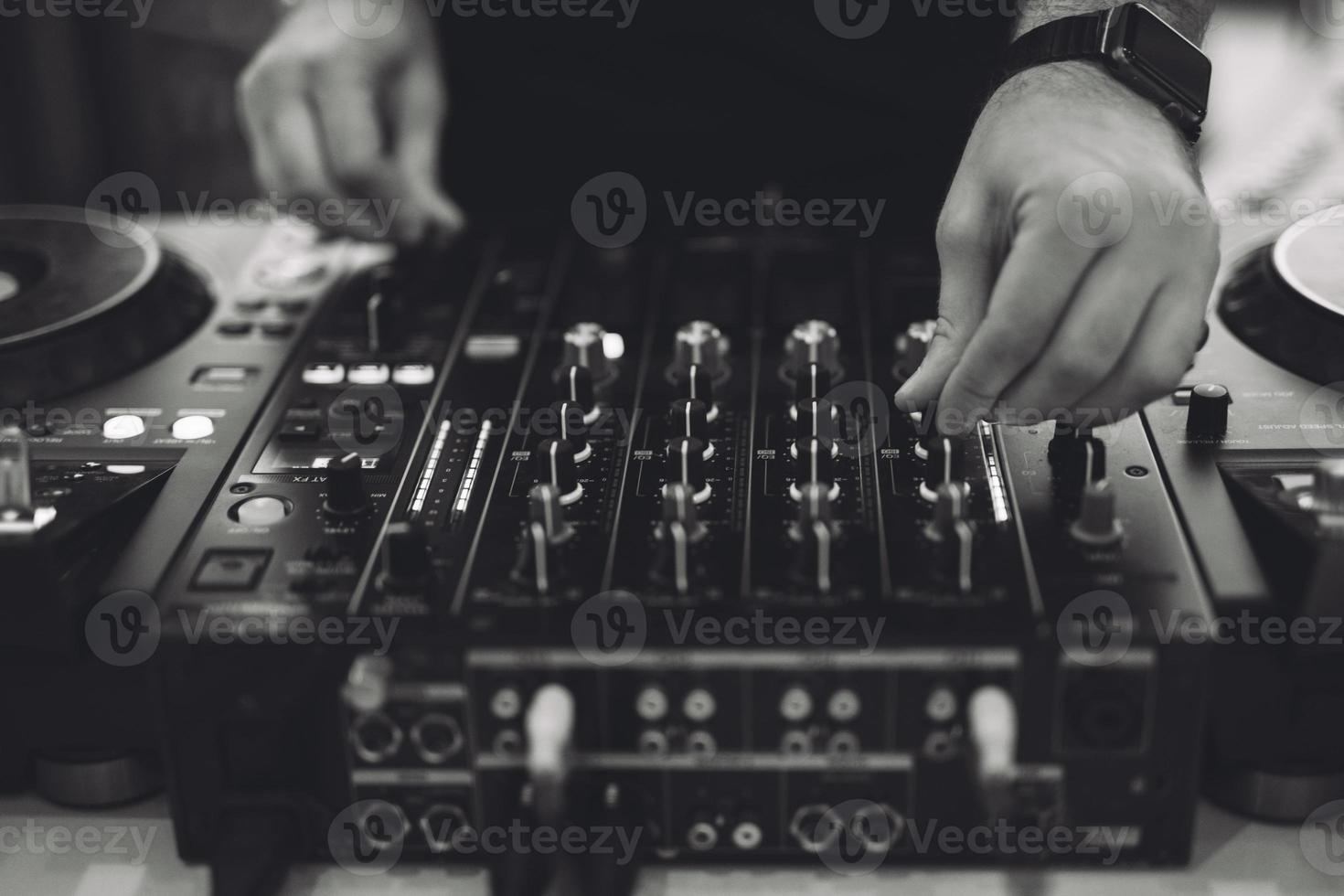 a DJ plays music on a controller at a party. photo