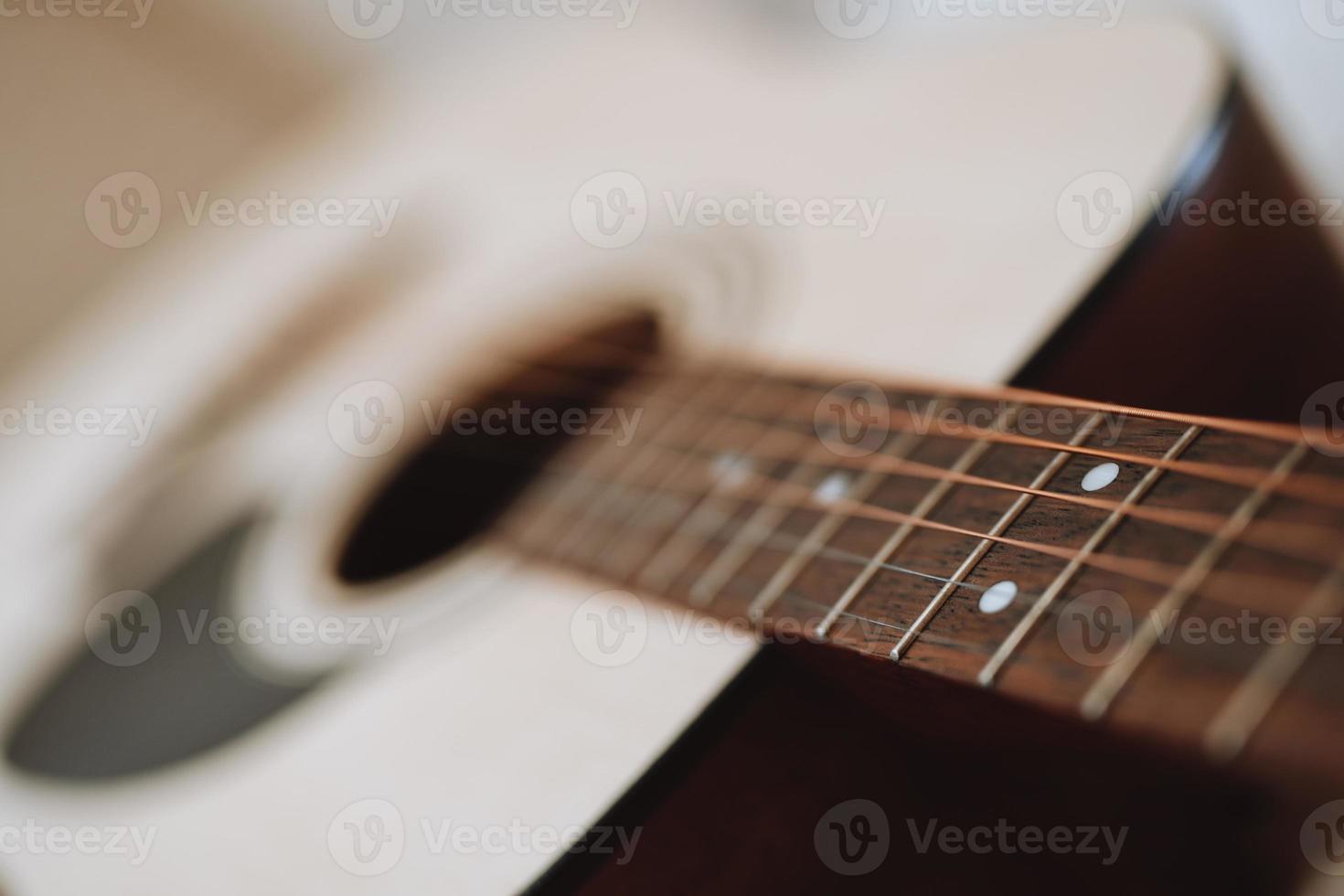 close up of classical acoustic guitar strings and neck with frets. photo