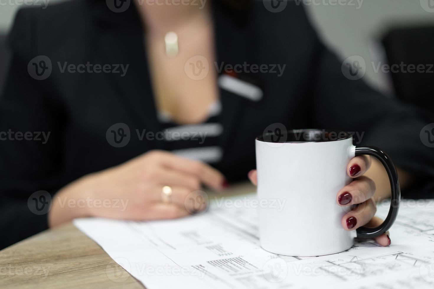 construction project drawing is viewed by construction company workers with a mug of tea. photo