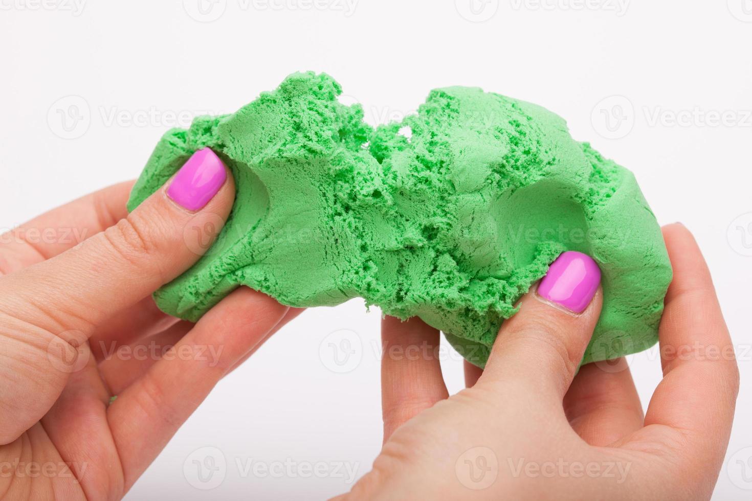 Close-up of a photo in the hands of kinetic sand on a white background