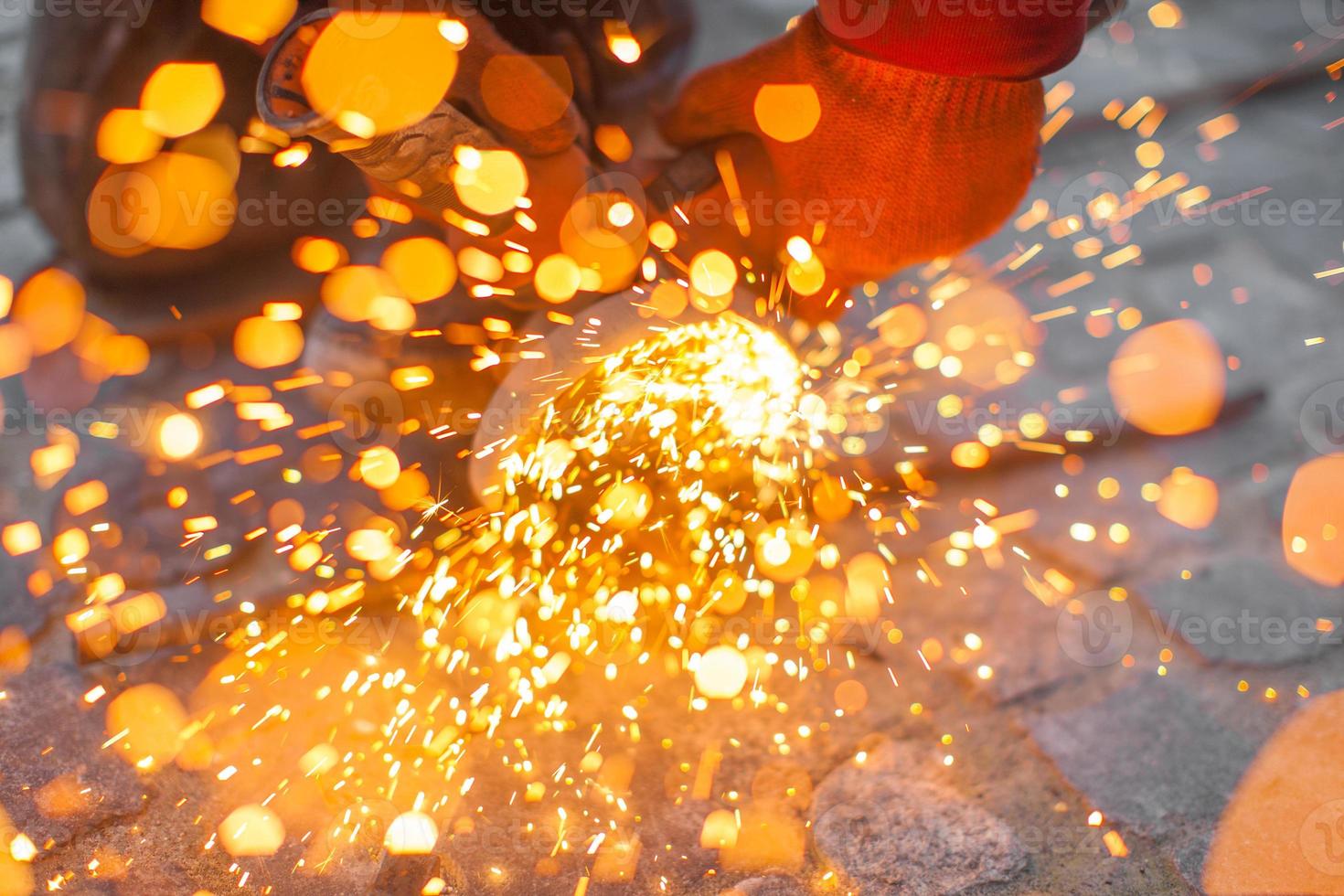 Angular grinding machine cuts metal with sparks photo