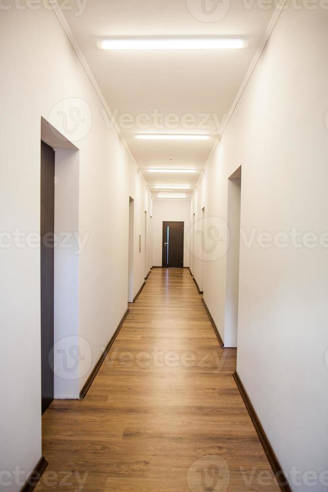 interior perspective of empty corridor with many doors photo