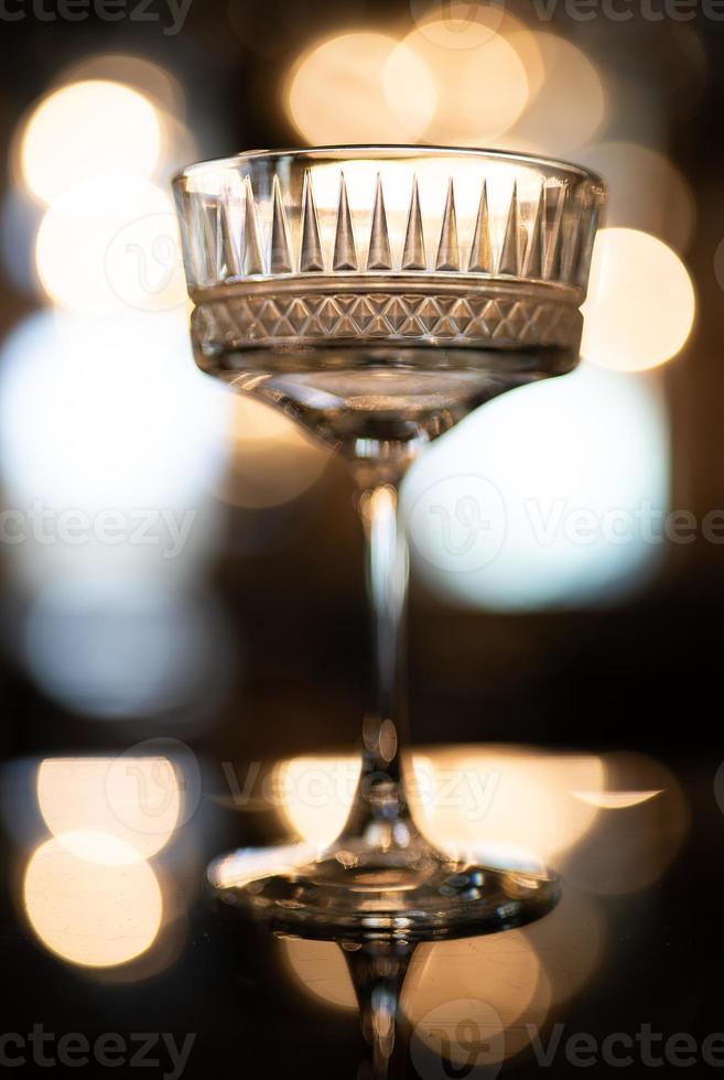 empty crystal glass on the bar with beautiful light and bokeh in the background. photo