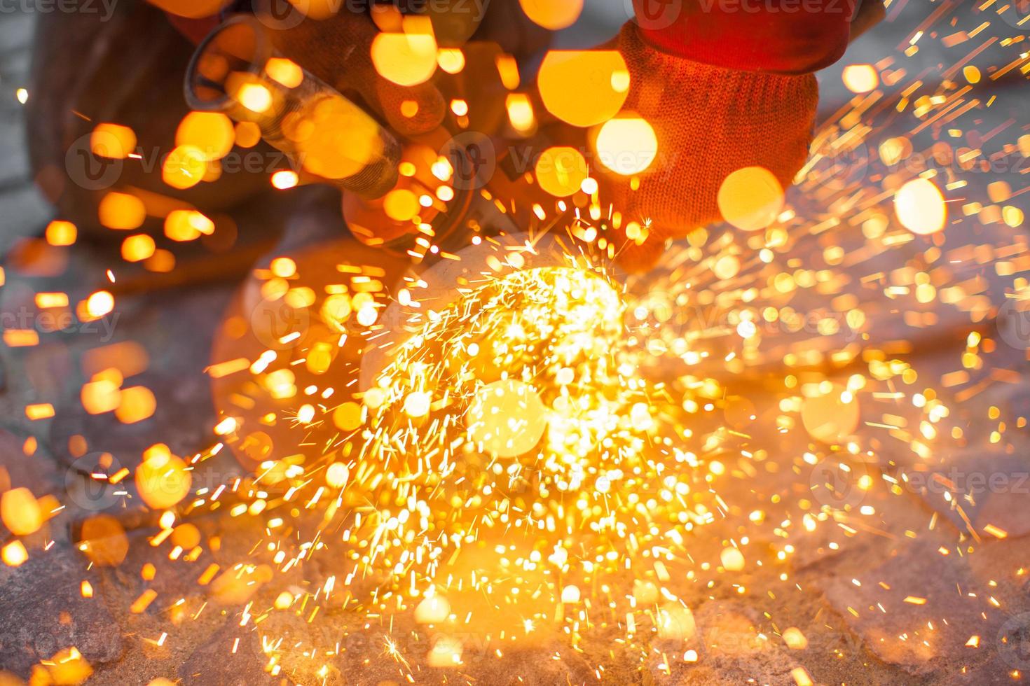 Angular grinding machine cuts metal with sparks photo