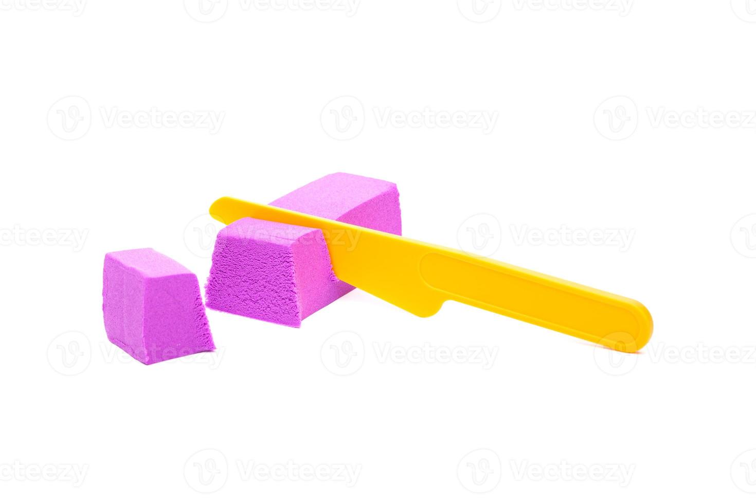 photo close-up of kinetic sand cut with a knife on a white background