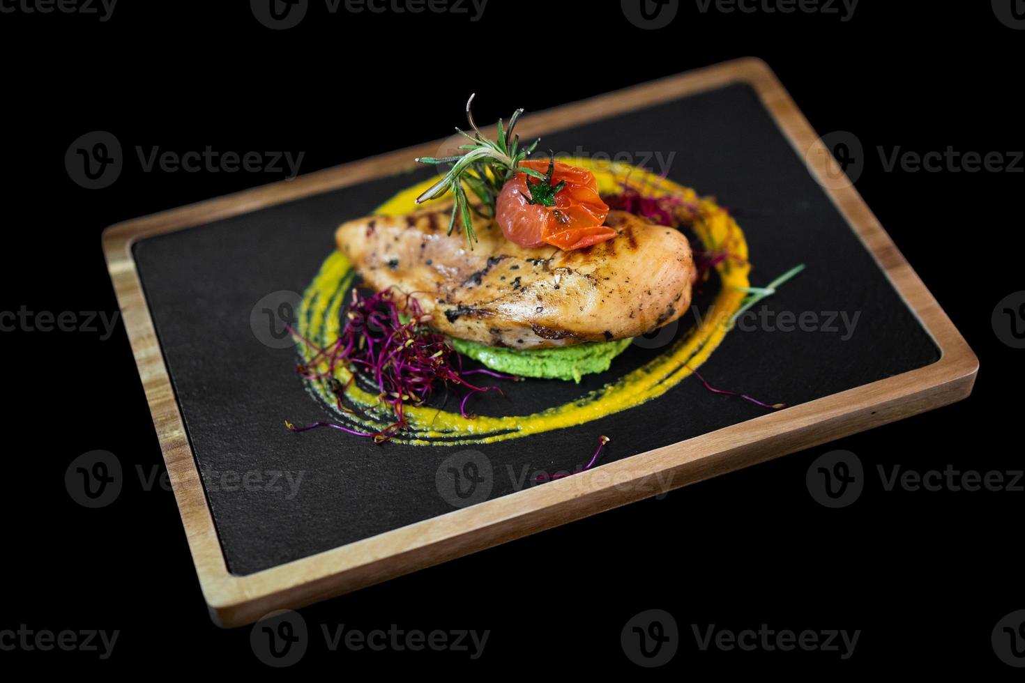 primer plano de una exquisita porción de un plato especial del chef en una pizarra negra foto