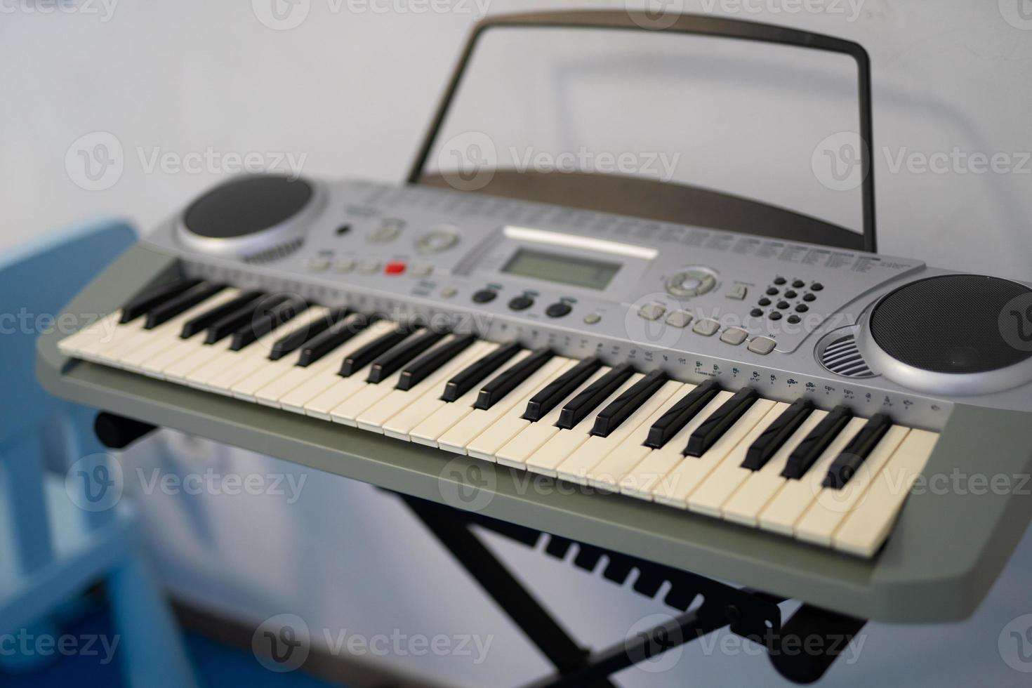 children's synthesizer, electronic piano on the stand for learning and practice. photo