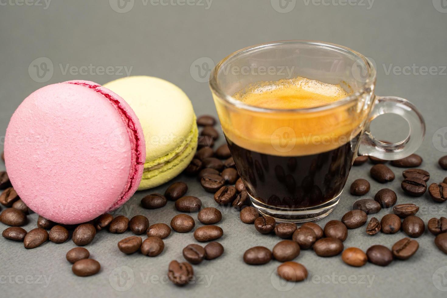 close up of coffee mug scattered coffee beans and  macarons cookies photo