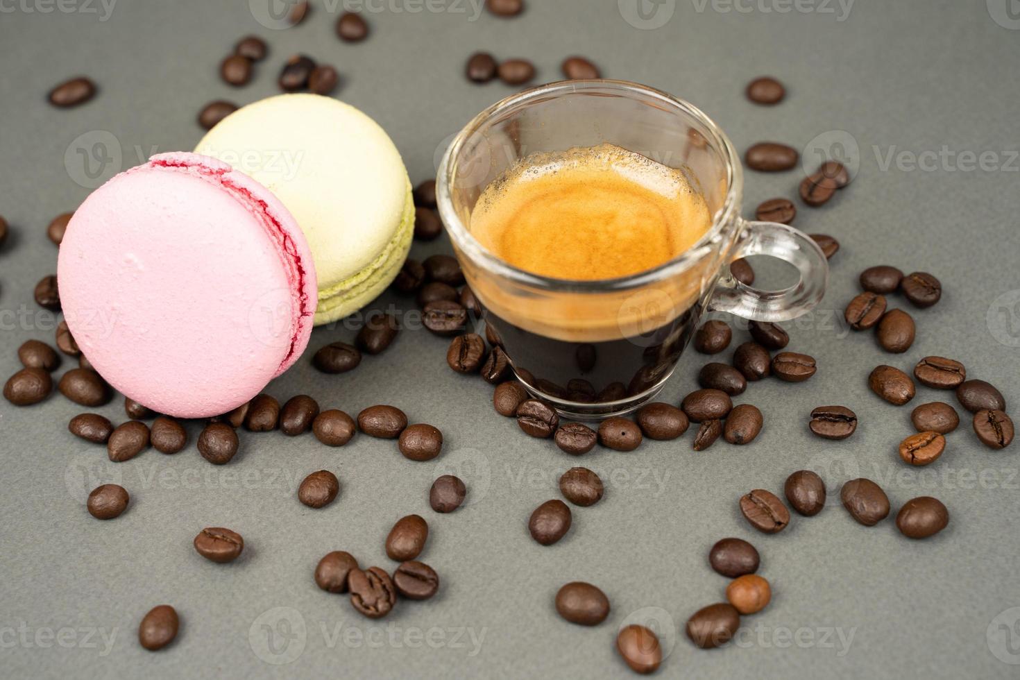 close up of coffee mug scattered coffee beans and  macarons cookies photo