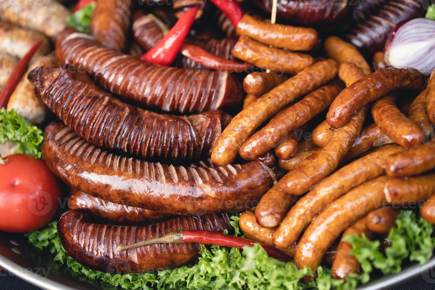delicious grilled sausages with salad and vegetables photo