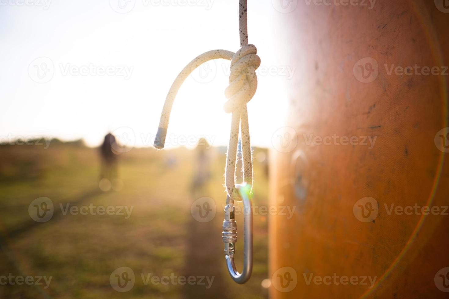 un mosquetón de escalador en un cordón en una hermosa luz de fondo foto
