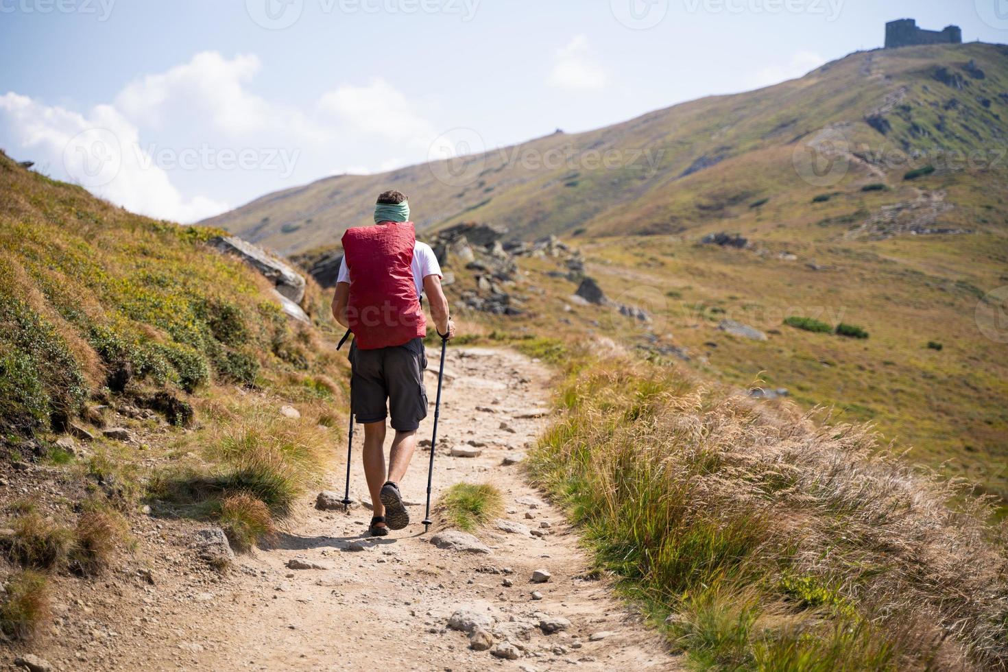 traveler with a backpack climbing to mountains photo