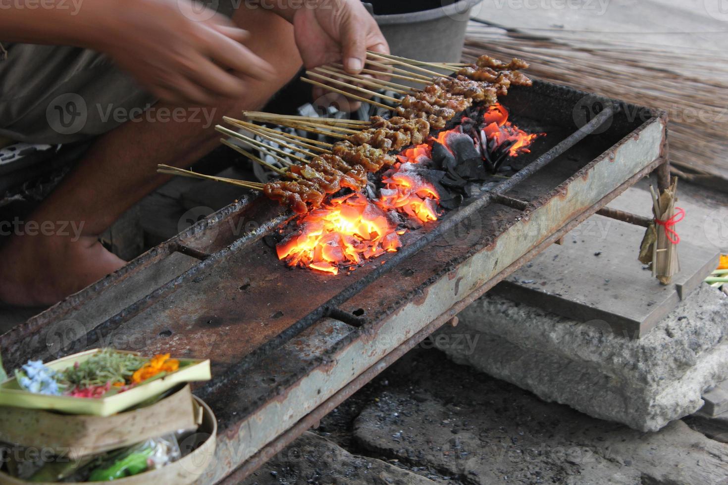 Photo of a pork satay making process in Bali.