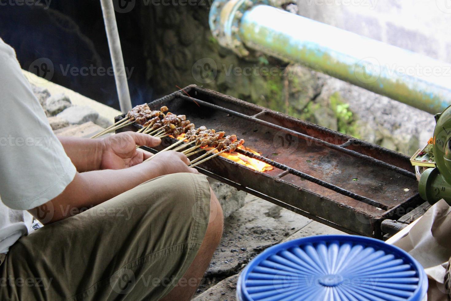 Photo of a pork satay making process in Bali.