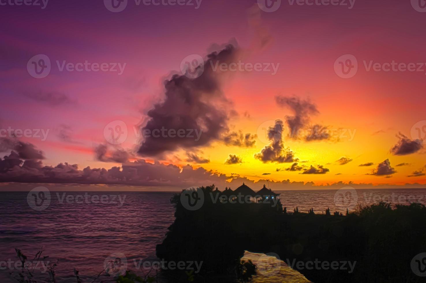 una belleza de la puesta de sol en el templo de tanah lot en bali. foto