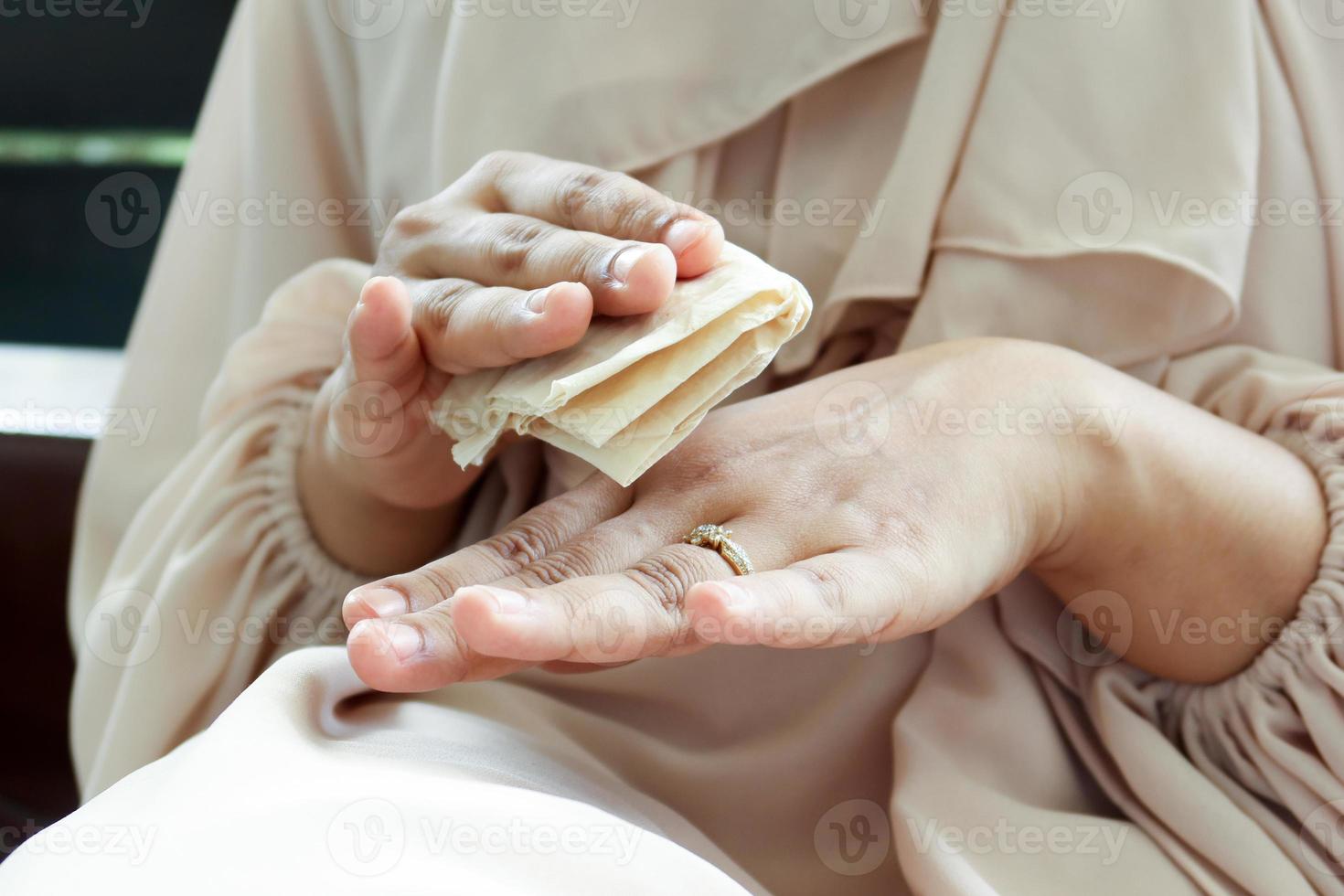 mujeres desinfectando sus manos con una toallita húmeda. foto