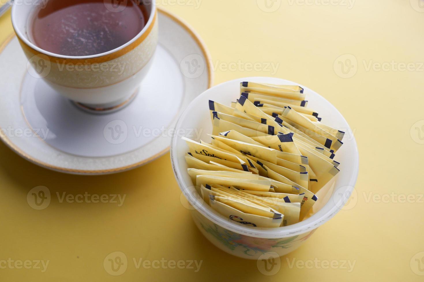 Sugar Substitute sweetener packet and tea cup on white background photo