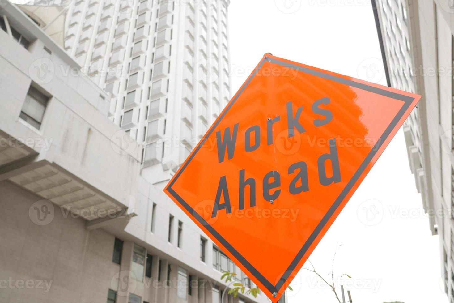 works ahead sign and buildings in singapore city photo