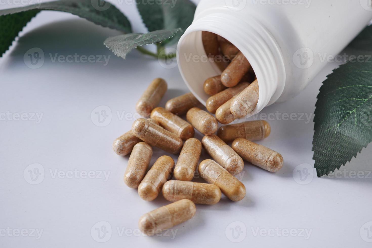 top view of herbal medicine capsule dropping on white photo