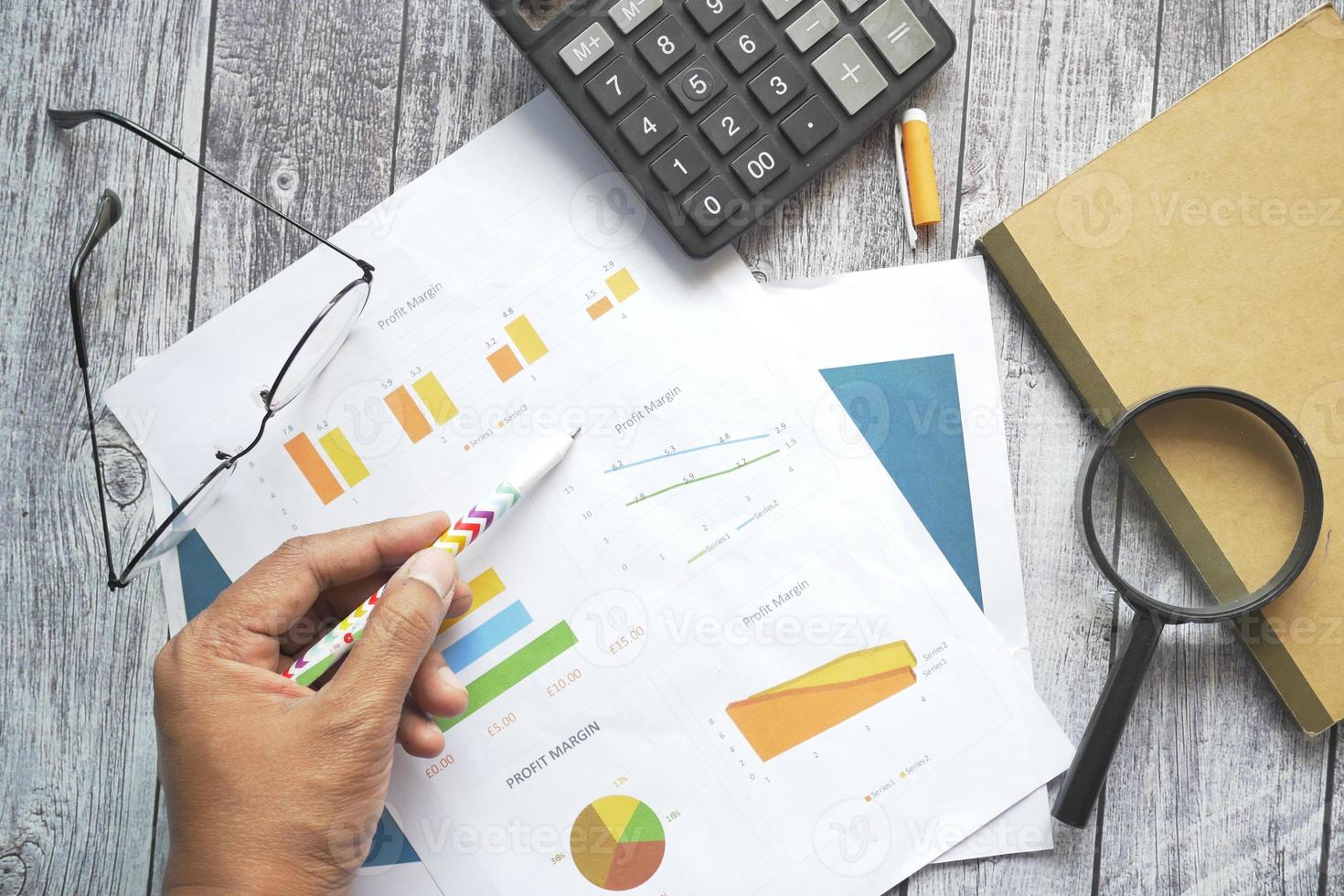 man hand with pen analyzing bar chart on paper photo