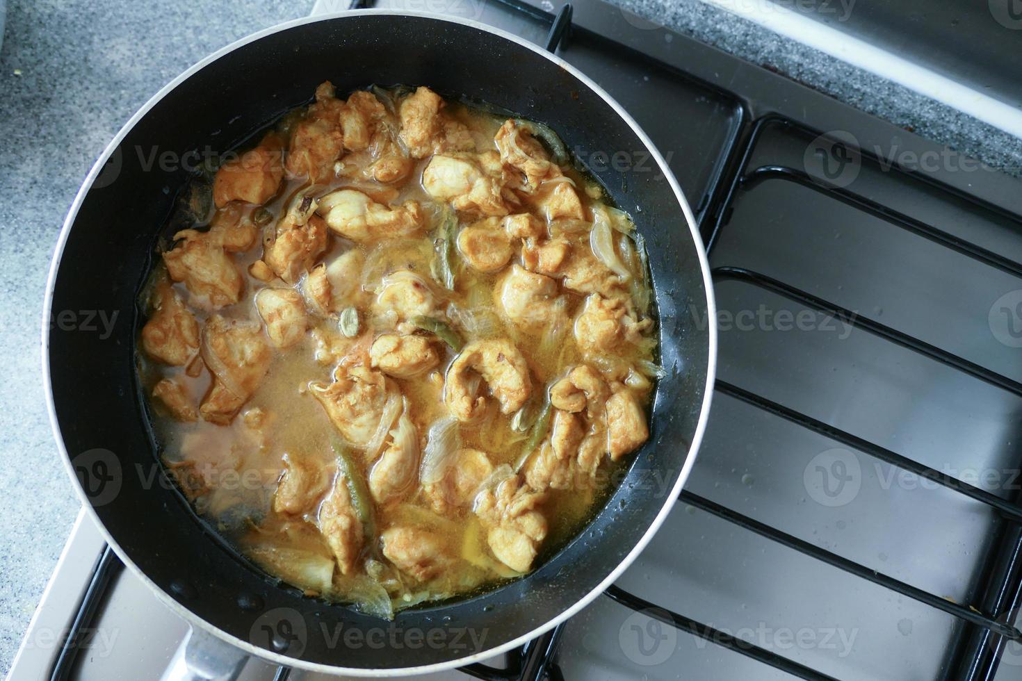 cooking chicken curry in a cooking pan photo