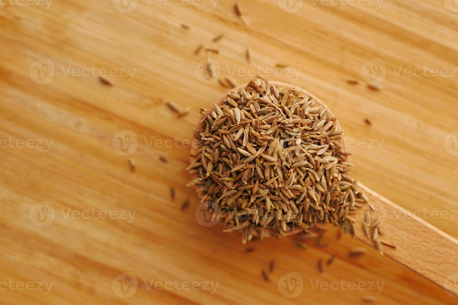 Semillas de comino en una cuchara sobre la mesa, cerrar foto