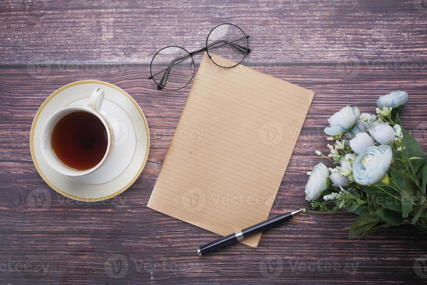 top view of Old Paper texture ,tea , flower on table photo