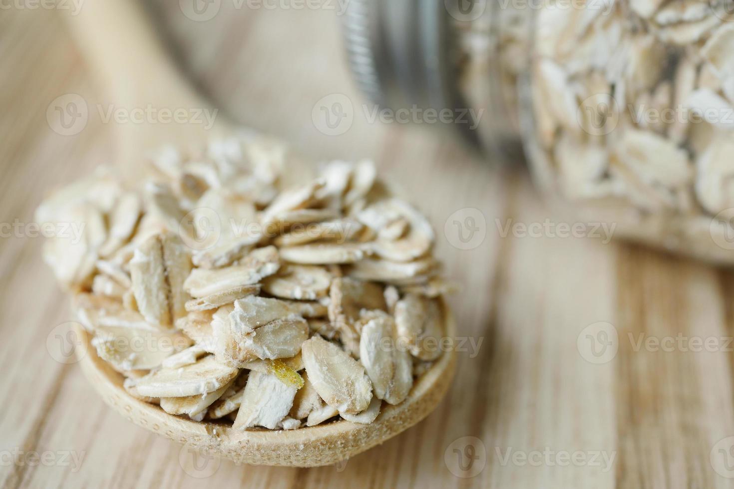 Close up of roasted oats flakes on spoon on table photo