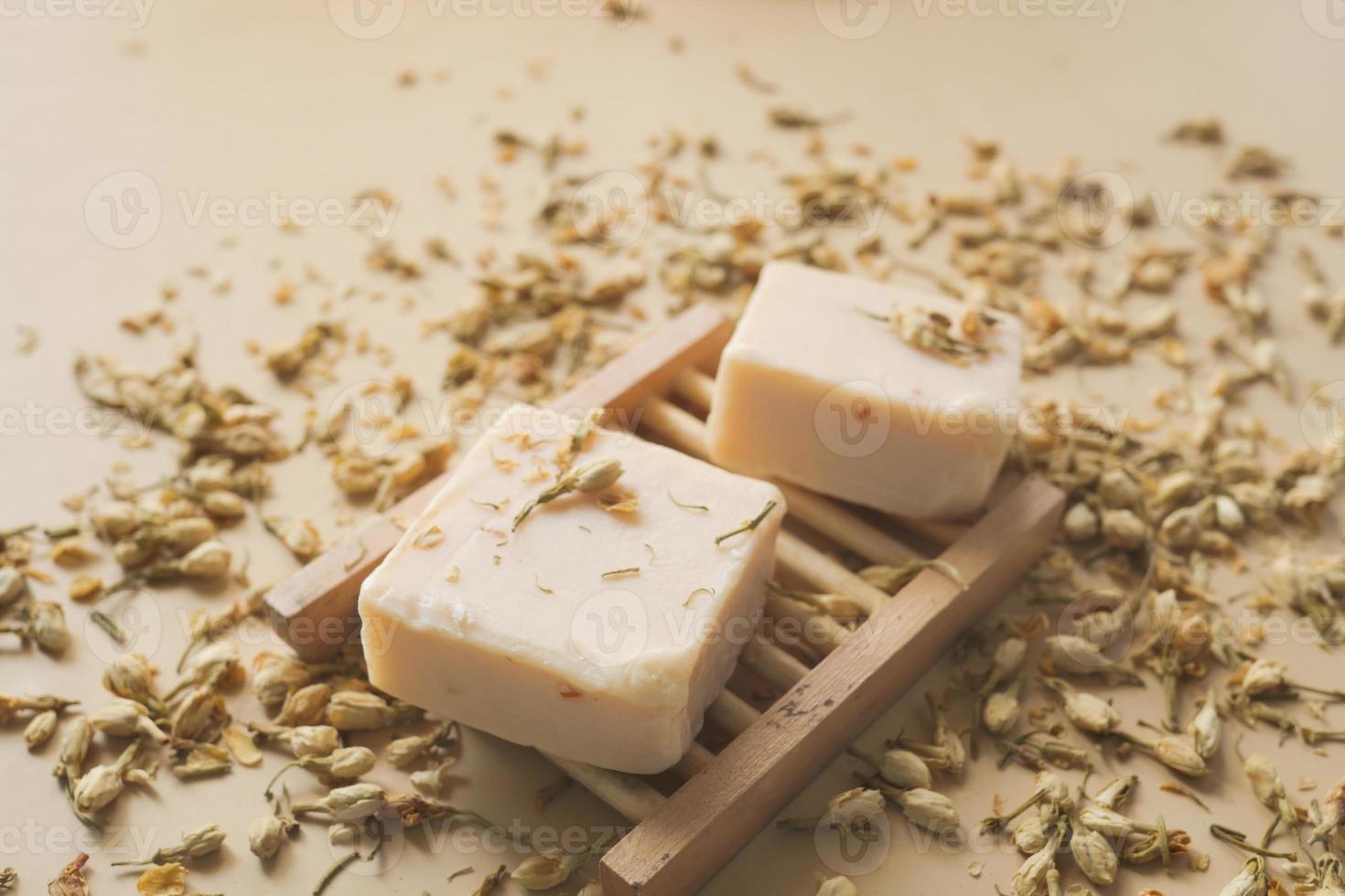 Homemade natural soap bar and dry flower on black background photo