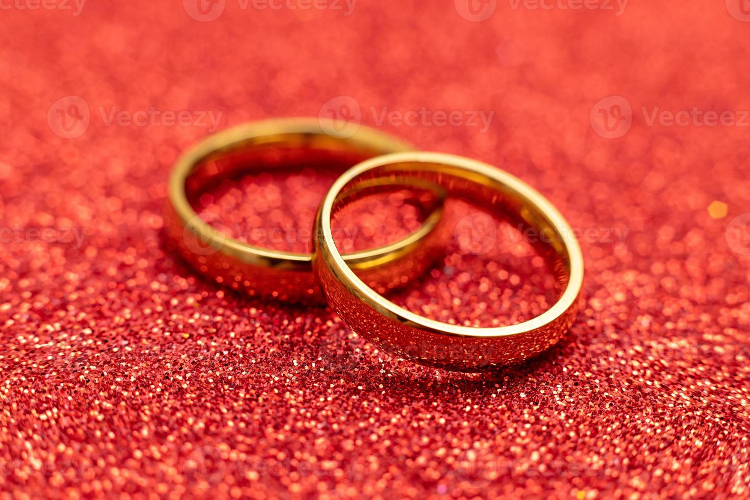 Will you marry me. Two golden wedding rings on red glitter background. Engagement marriage proposal wedding concept. St. Valentine's Day postcard. Banner on valentines day. Copy space. photo