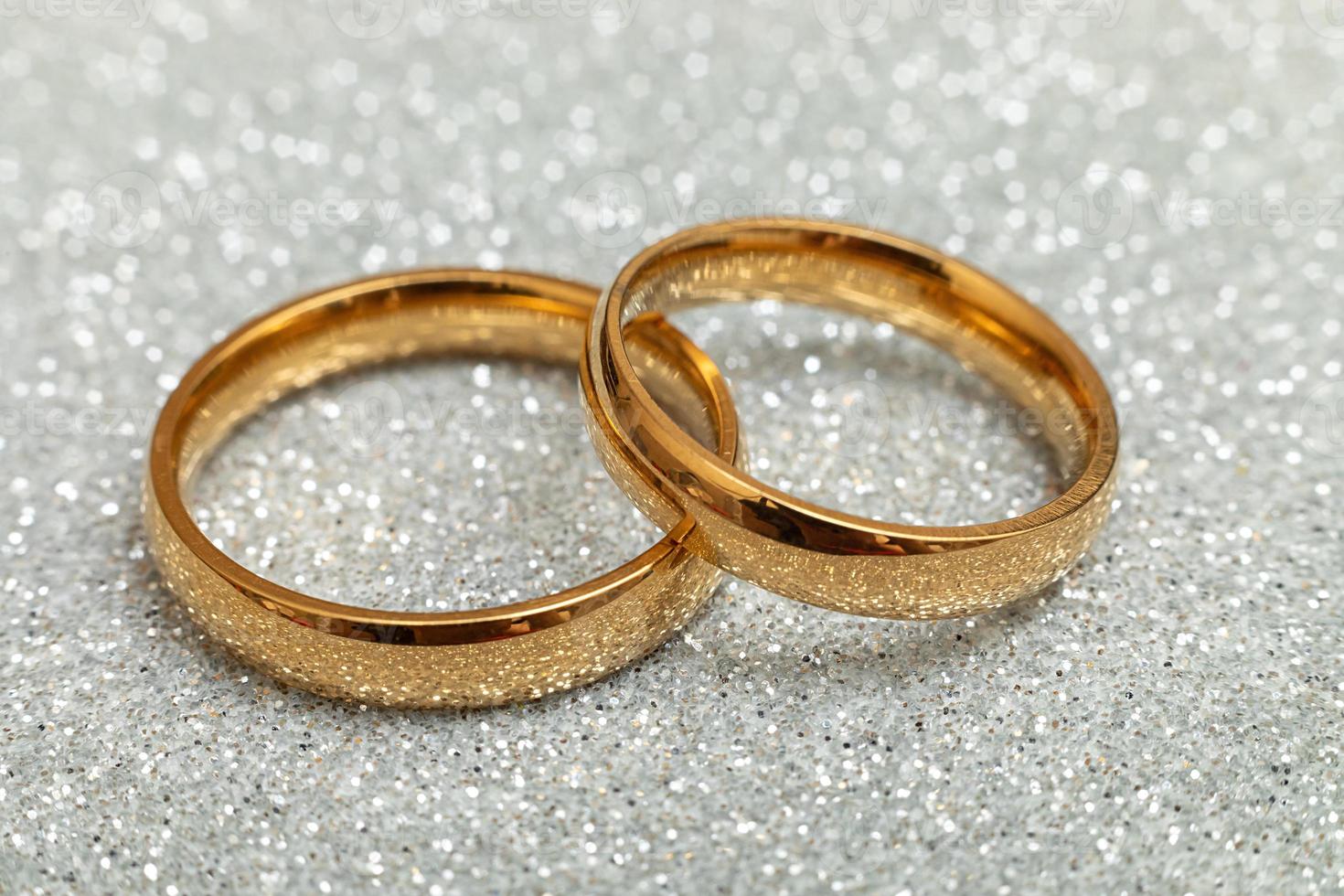 Te casarías conmigo. dos anillos de boda dorados fondo plateado brillante. concepto de boda de