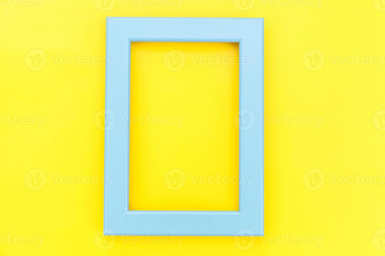 Simply design with empty blue frame isolated on yellow colourful trendy background. Top view, flat lay, copy space, mock up. Minimal concept. photo