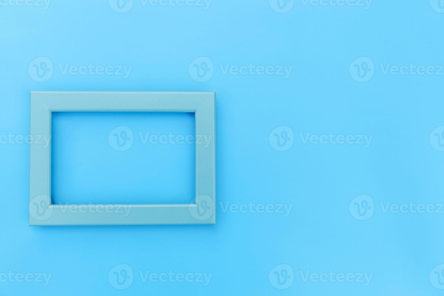 Simply design with empty blue frame isolated on blue pastel colorful background. Top view, flat lay, copy space, mock up. Minimal concept. photo