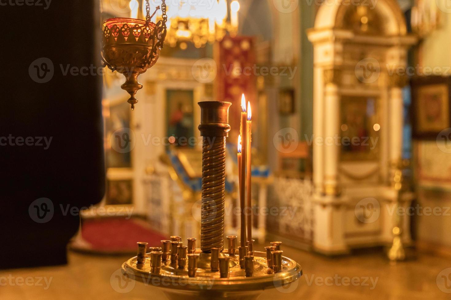 Iglesia Ortodoxa. cristiandad. decoración interior festiva con velas encendidas e icono en la iglesia ortodoxa tradicional en vísperas de pascua o navidad. religión fe orar símbolo. foto