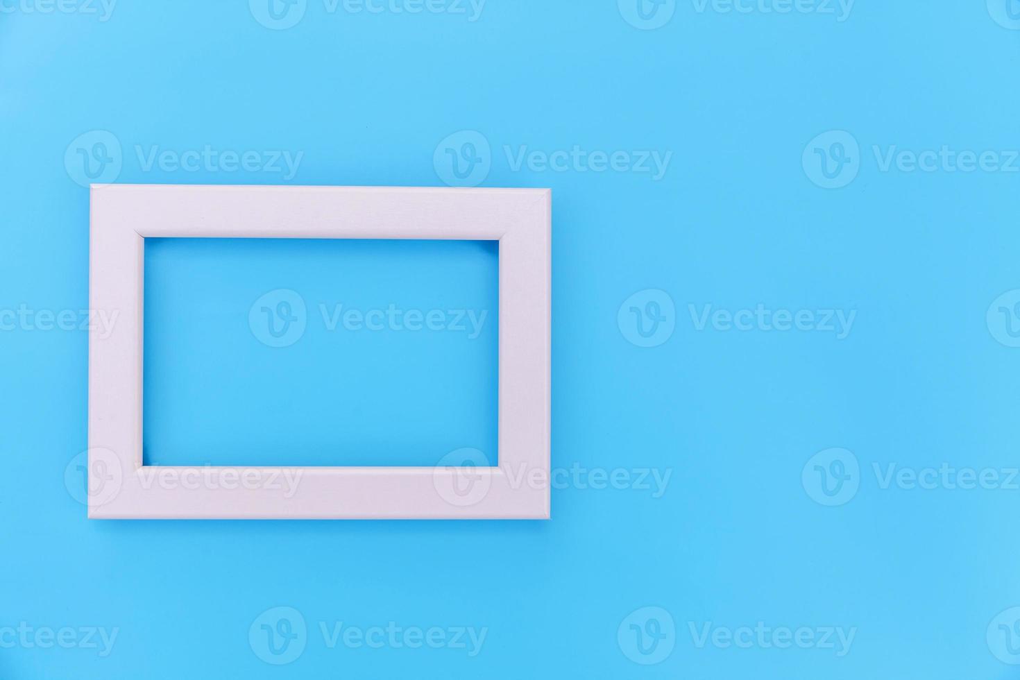 Simply design with empty pink frame isolated on blue pastel colorful background. Top view, flat lay, copy space, mock up. Minimal concept. photo