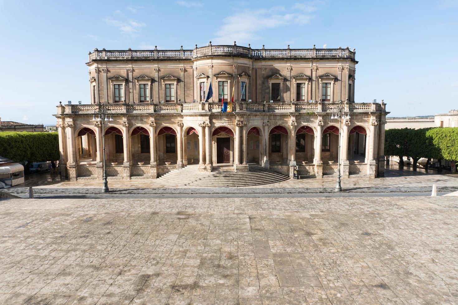 Noto,Italy-May 8, 2022-View of the Ducezio palace from from the top of the stairway of the Cathedral during a sunny day photo