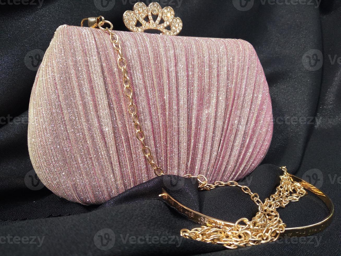 The shining pink bag looks elegant with a golden colored chain strap suitable for going to parties or invitations photo