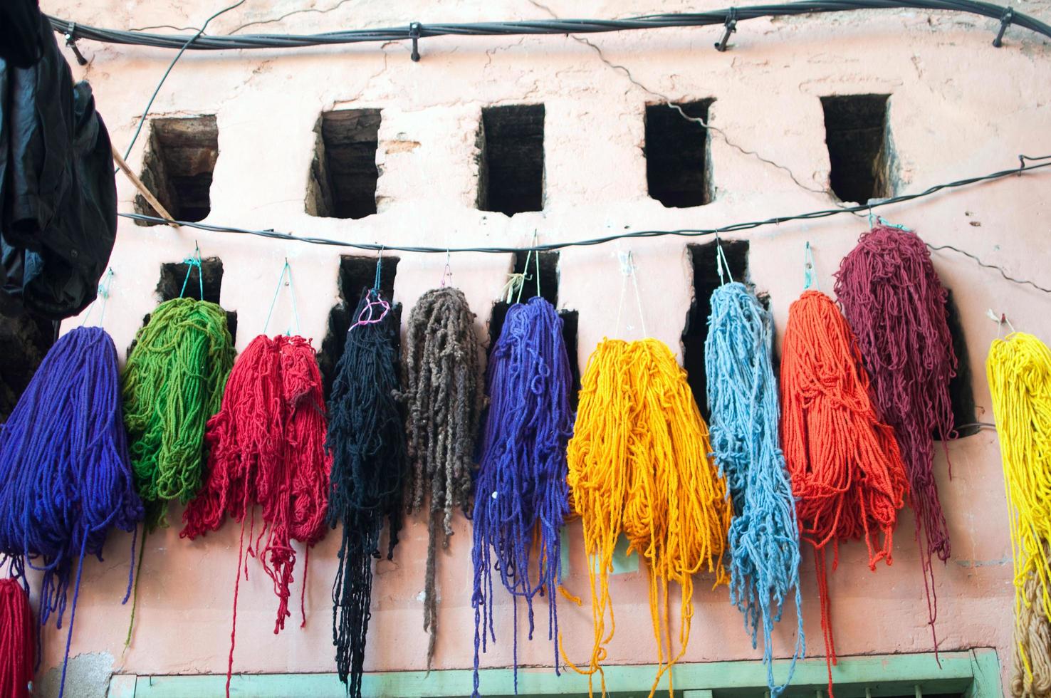 Multicolored skeins of wool hanging in a rope photo